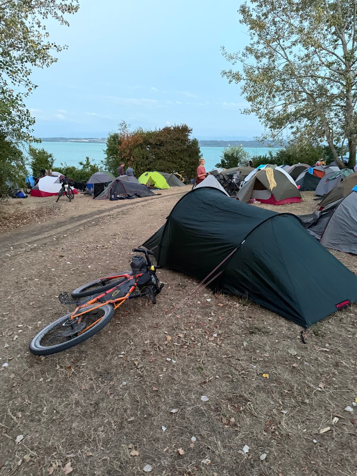 Zeltlager am Neuenburgersee im Abendlicht, Velo im Gras